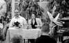 Stadtschreiberin Julia Kulewatz und Florian L. Arnold sitzen an einem Tisch, um sie herum viele Pflanzen